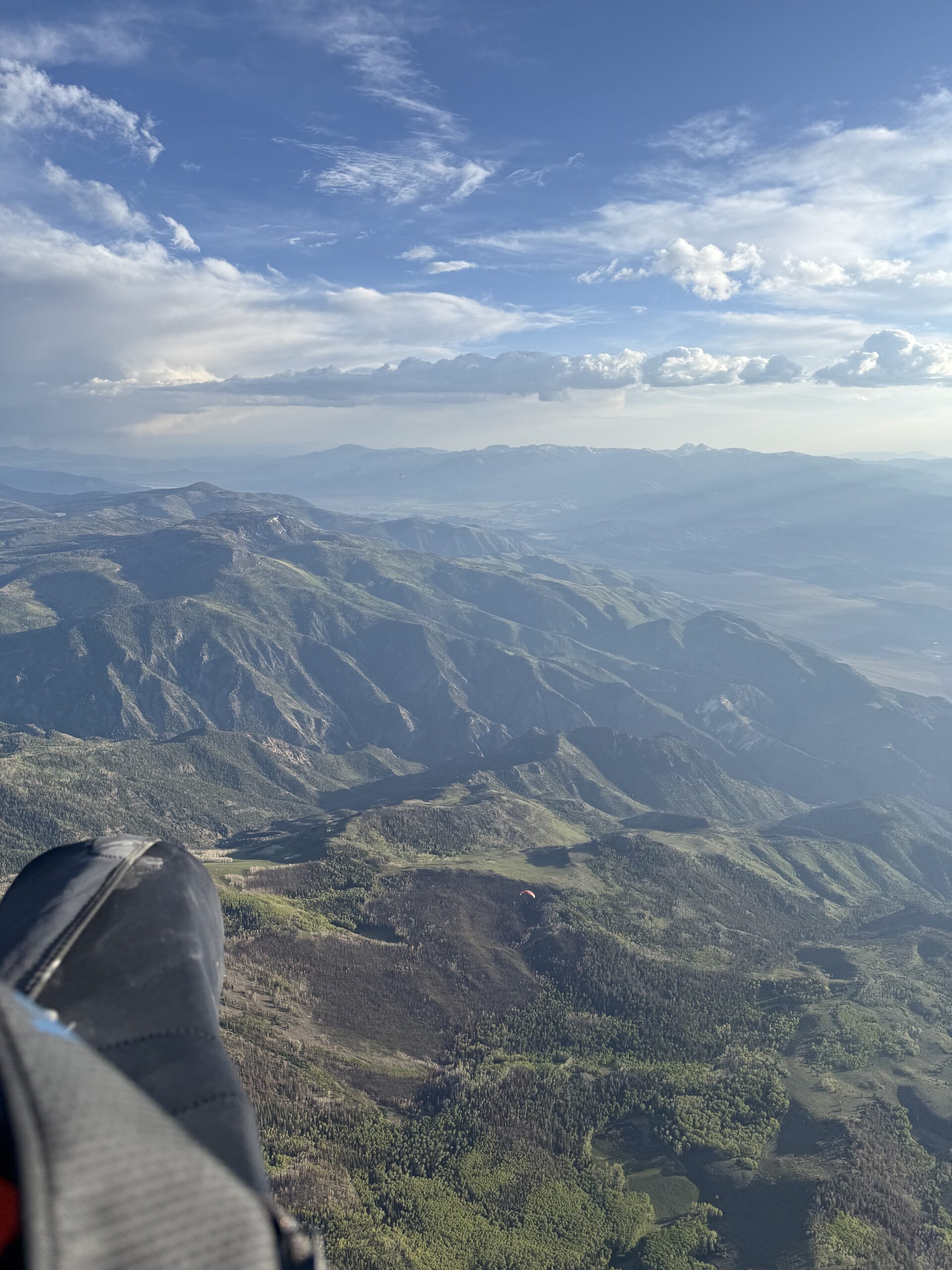 Paragliding over forested mountain terrain on a trip abroad